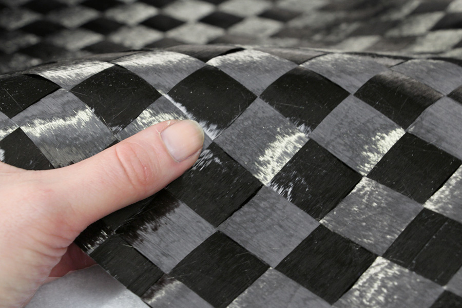 Spread-tow-carbon-fibre-plain-weave-25mm-in-hand-close-up.jpg